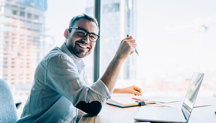 Business men at desk using capital budgeting software Business man at desk using capital planning software